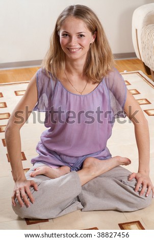 Young girl is sitting on the floor with crossed legs