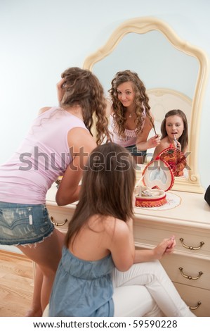 Two young girls near mirror during make-up