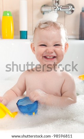 Little baby girl having soapy bath at home