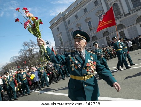 Celebratory parade of veterans of Great domestic war ( Second Warld War ). Day of a victory. Nevskiy prospectus. Old man - soldier of the warld war 2 with flowers celebrates a victory over fascism