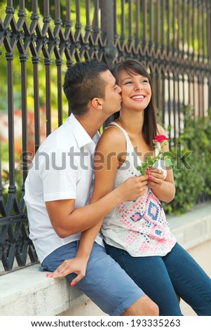 Young man giving red rose to his girlfriend