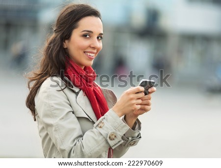 Beautiful young woman on the street with smart phone.
