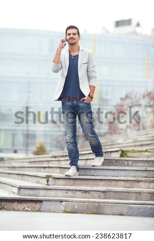 Young man walking down the stairs talking on the phone