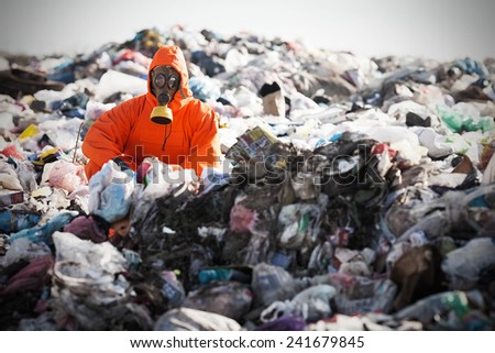 Portrait of recycling worker among garbage bags on the landfill