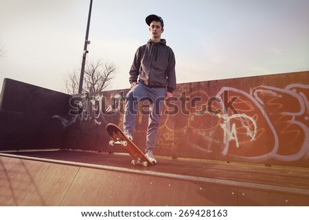 Young man standing on a skateboard preparing for a jump on a skate ramp