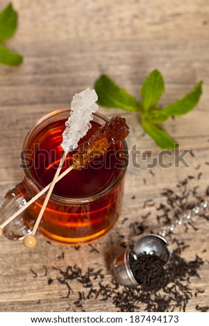 Tea with Mint Leaf and Candy Brown Sugar on a Sticks. Selective focus