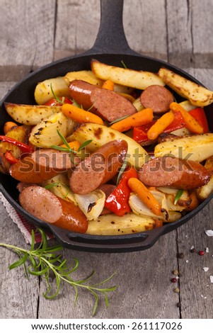 Homemade roasted polish sausages and vegetables dinner. Selective focus.