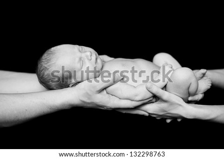 Newborn baby sleeps in A Father hands. Black-and-white photo