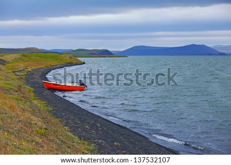 Iceland landscape with red boat on Myvatn lake in northern Iceland
