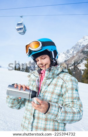 Ski, skier, winter. Lovely girl has a fun on ski - resting and drinking tea from a thermos.