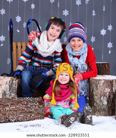 Winter Fashion. Adorable happy boy and girls in winter hat, gloves and sweater in studio.
