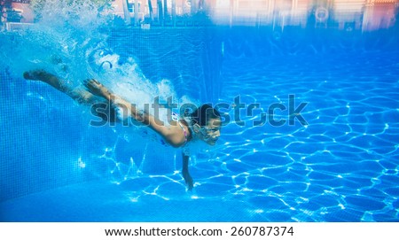 Underwater happy cute girl in swimming pool