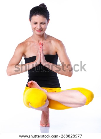 Yoga woman - pretty brunette in active wear doing yoga on white background