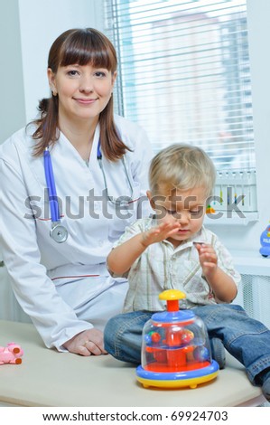 Young and cute female doctor visiting with a stethoscope a little boy