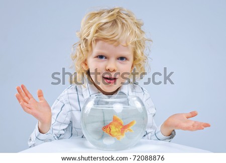 Cute little boy with a fish in an aquarium. In the studio