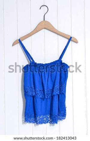 female, blue clothes on wooden hangers-wooden background