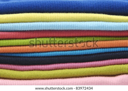 Rainbow clothes background. Pile of bright peignoir folded clothes.