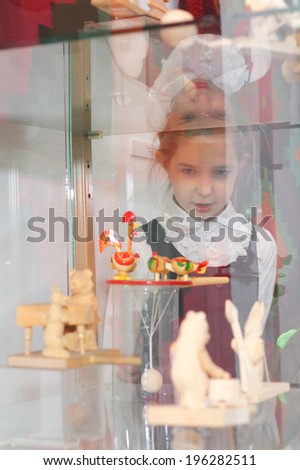 little girl looking at the russian art toys in museum