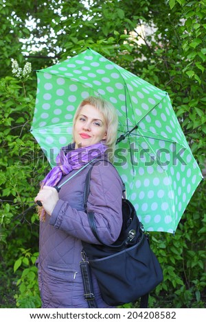 pretty young woman with the big green umbrella outdoors
