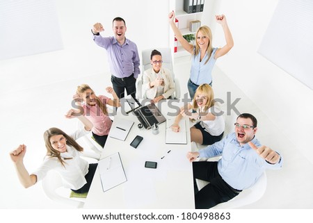 Group of a happy Successful Business People showing thumbs up and expressing positivity with raised arms.