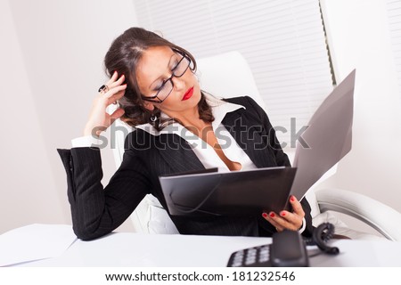 Beautiful attractive business woman with glasses reading business documents