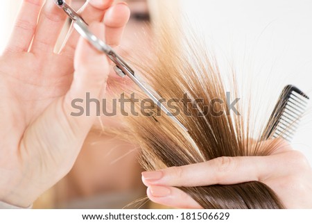 Hairdresser cut hair of a woman. Close-up. Selective focus. Focus on hair.