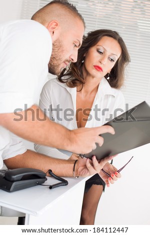 Business man and business woman looking in folder and considering about business project.