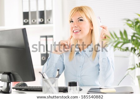 Businesswoman in the office. Sitting at the table with computer and thinking.