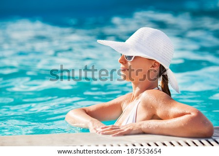 Young beautiful woman enjoying the sun in the pool.