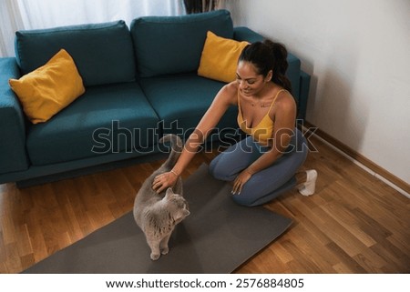 Similar – Image, Stock Photo young woman kneeling on floor feeding snacks to her cat