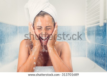 Beautiful girl washing the face with water in the bathroom.