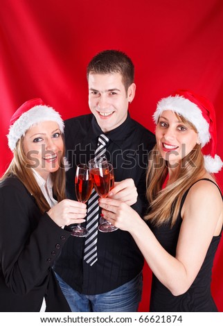 Smiling young people with Christmas hats on, toasting Christmas with Champagne