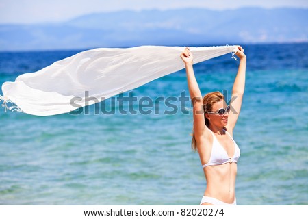 Beautiful Woman with scarf enjoying on the beach