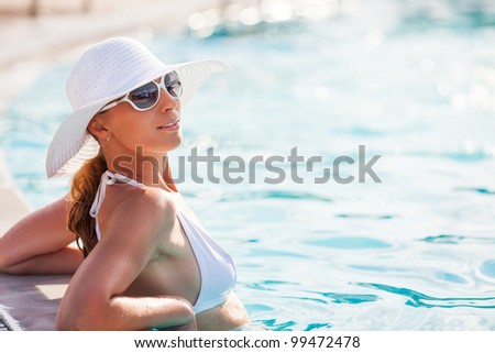 Young beautiful woman enjoying the sun in the pool