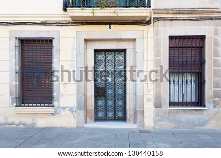 A typical facade of the SarriÃ?Â  quarter of Barcelona, Spain (one door, two windows). In this area, ground level homes abound and many doors and windows preserve the same look they had some decades ago.