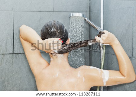 Woman is washing her brown hair