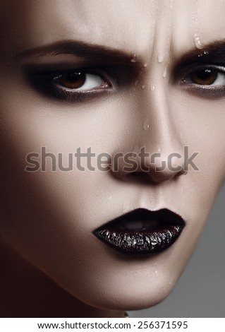 Dark portrait of woman with purple lips close-up