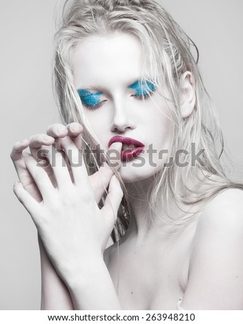 High Fashion Beauty Model Girl with blue Make up and Long Lushes. Red Lips. Dark Lipstick and White Skin. Vogue Style Portrait