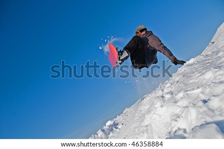 Extreme sports: snowboarder flying in air, snow crystals flying everywhere