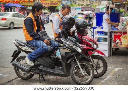 BANGKOK, THAILAND - FEB 20, 2015: Taxi drivers on scooters waiting for customers in Bangkok. Motorbike taxis are a popular choice for the Thai  heavily congested roads