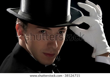 young magician with high hat on black background