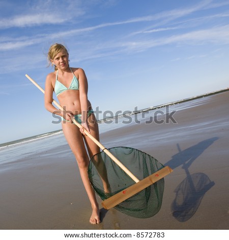girl showing her fishing net (for shrimps) at the beach