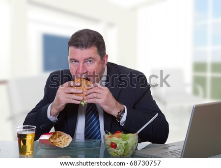 man at office working and eat unhealthy fast food