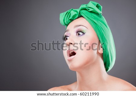 Surprised beautiful woman with green scarf on head with wow expression; open mouth and eyes