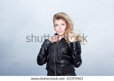 Beautiful blonde woman with her hair blowing looking at camera