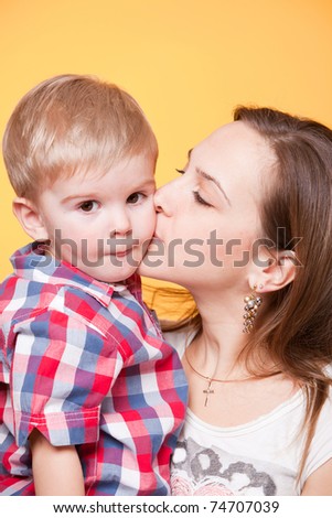Happy mom kissing little son, closeup portrait