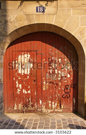 Grunge painted wooden door with graffiti in Paris