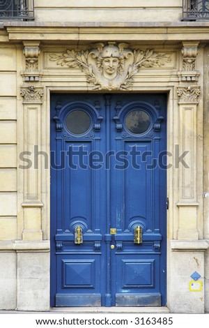 Classic painted wooden door with bronze handles in Paris