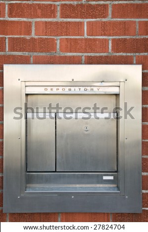 Night stainless steel depository box on brick bank wall
