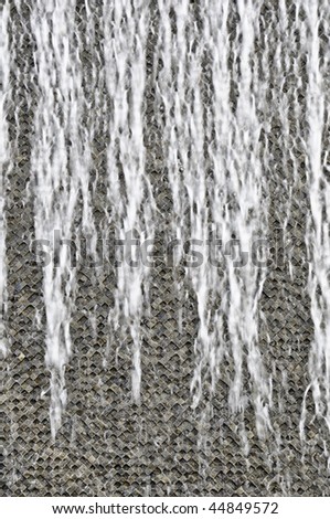 Water running over patterned concrete wall - modern fountain